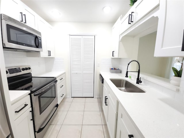 2935 Lichen Ln Unit D, Clearwater, FL 33760 - kitchen featuring appliances with stainless steel finishes, light countertops, decorative backsplash, white cabinetry, and light tile patterned floors