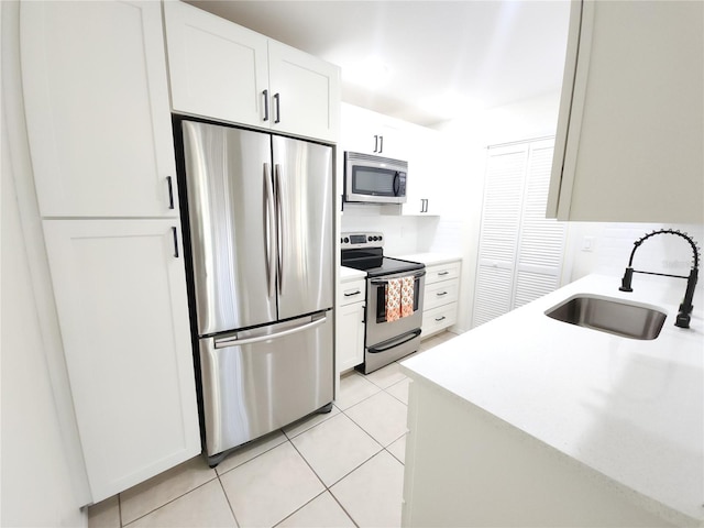 2935 Lichen Ln Unit D, Clearwater, FL 33760 - kitchen featuring appliances with stainless steel finishes, backsplash, light tile patterned flooring, and white cabinets