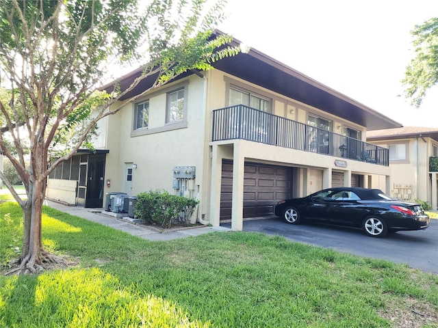 2935 Lichen Ln Unit D, Clearwater, FL 33760 - view of home's exterior featuring stucco siding, asphalt driveway, a lawn, and an attached garage