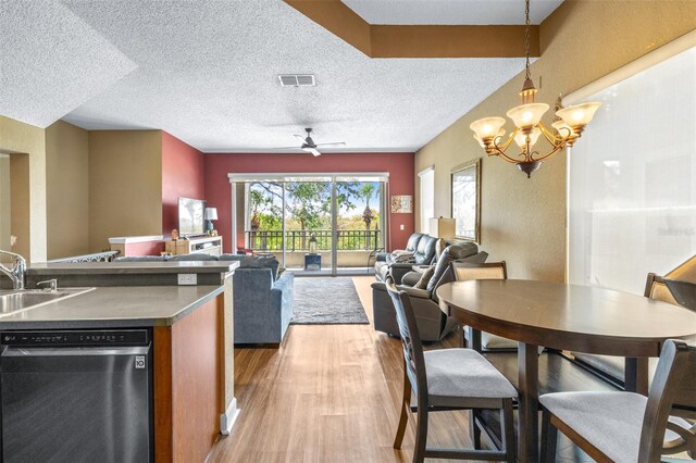 731 Cruise View Dr, Tampa, FL 33602 - kitchen featuring dishwasher, open floor plan, light wood-type flooring, dark countertops, and a sink