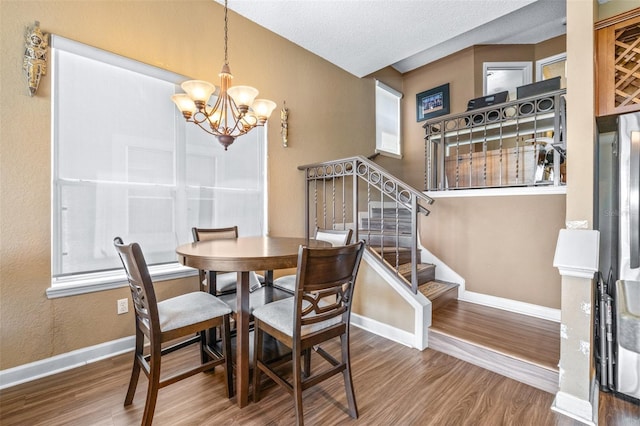 731 Cruise View Dr, Tampa, FL 33602 - dining space featuring wood finished floors, a chandelier, stairway, baseboards, and a textured ceiling