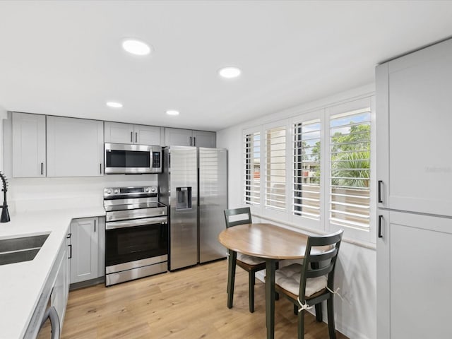 3062 Eastland Blvd Unit 405, Clearwater, FL 33761 - kitchen with stainless steel appliances, a sink, light wood finished floors, light countertops, and gray cabinets
