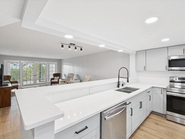 3062 Eastland Blvd Unit 405, Clearwater, FL 33761 - kitchen featuring appliances with stainless steel finishes, open floor plan, a sink, light countertops, and recessed lighting