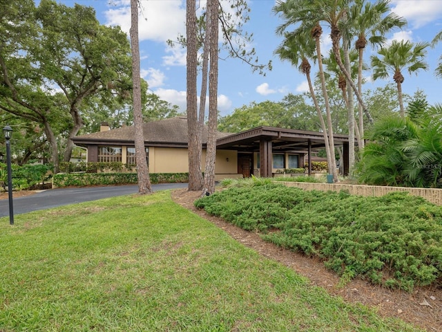 3062 Eastland Blvd Unit 405, Clearwater, FL 33761 - mid-century modern home with a chimney, asphalt driveway, and a front lawn