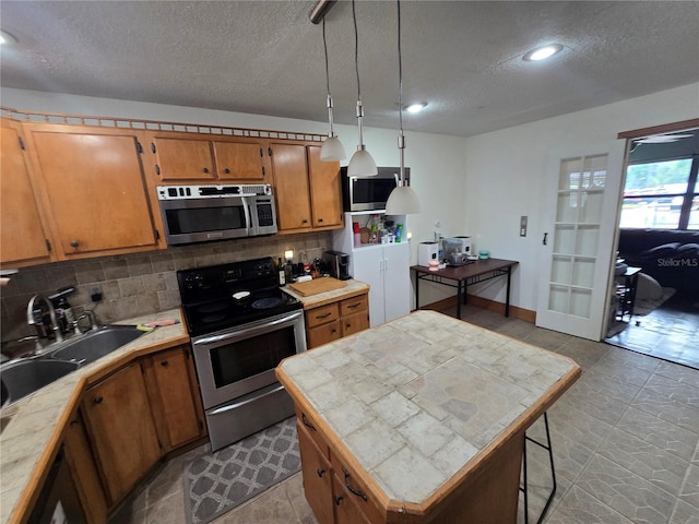 7920 52nd St N, Pinellas Park, FL 33781 - kitchen featuring stainless steel appliances, a textured ceiling, tasteful backsplash, brown cabinets, and a sink