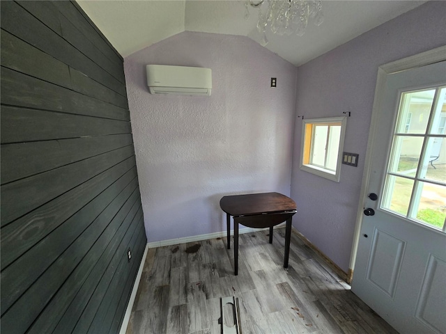 7920 52nd St N, Pinellas Park, FL 33781 - doorway featuring a wall mounted AC, healthy amount of natural light, lofted ceiling, wood finished floors, and a chandelier