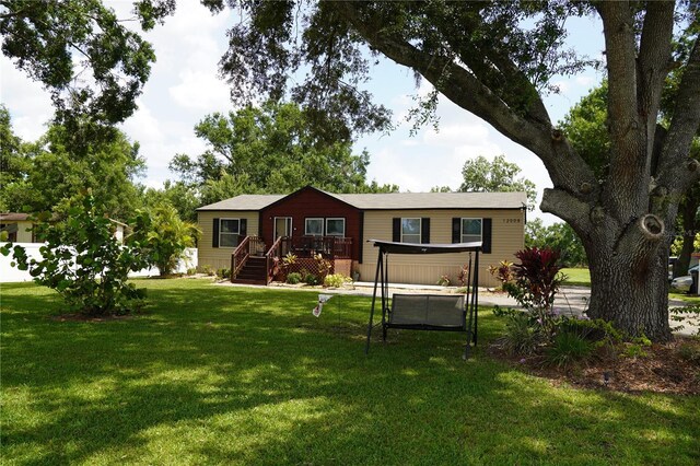 12008 Rose Ln, Riverview, FL 33569 - view of front of house with a front lawn and a wooden deck