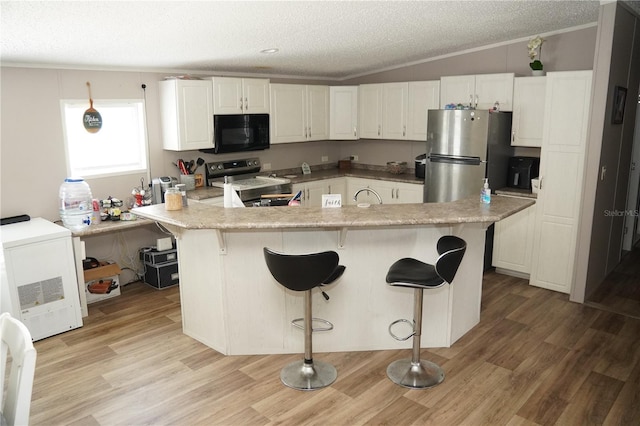 12008 Rose Ln, Riverview, FL 33569 - kitchen featuring appliances with stainless steel finishes, lofted ceiling, a textured ceiling, crown molding, and white cabinetry