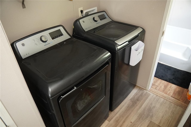 12008 Rose Ln, Riverview, FL 33569 - laundry area with independent washer and dryer and light wood-style floors