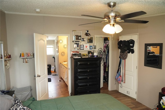 12008 Rose Ln, Riverview, FL 33569 - bedroom with wood finished floors, crown molding, a textured ceiling, a ceiling fan, and a closet
