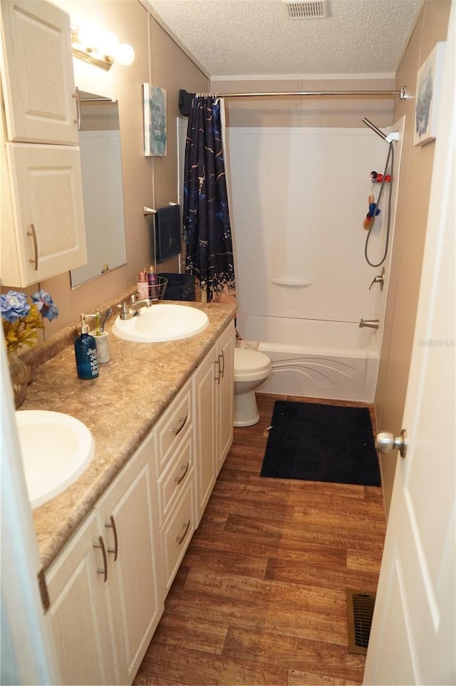 12008 Rose Ln, Riverview, FL 33569 - full bathroom featuring a textured ceiling, shower / tub combo, wood finished floors, double vanity, and toilet
