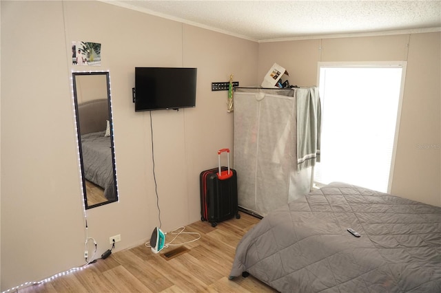 12008 Rose Ln, Riverview, FL 33569 - bedroom with wood finished floors, crown molding, and a textured ceiling
