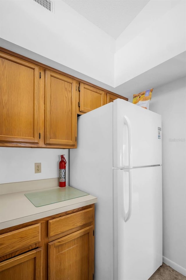 2749 Countryside Blvd Unit 20, Clearwater, FL 33761 - kitchen with freestanding refrigerator, light countertops, and brown cabinetry