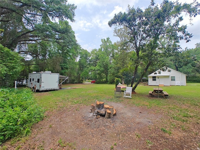 18452 Fort Dade Ave, Brooksville, FL 34601 - view of green lawn featuring a fire pit, an outbuilding, and view of scattered trees