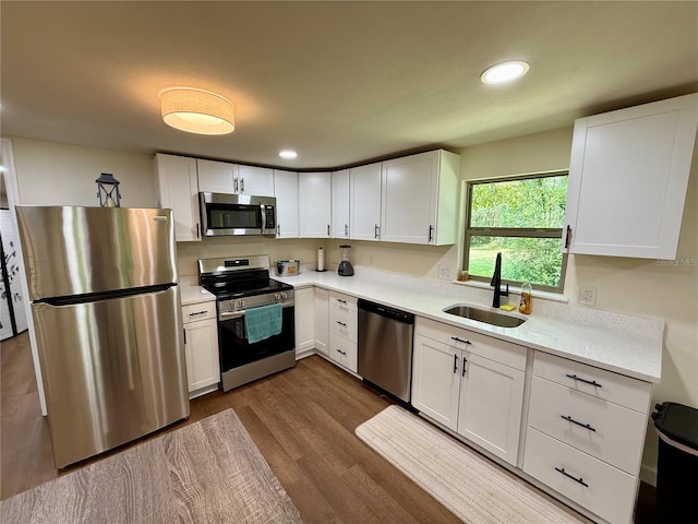 18452 Fort Dade Ave, Brooksville, FL 34601 - kitchen with stainless steel appliances, a sink, dark wood-style flooring, light countertops, and white cabinets