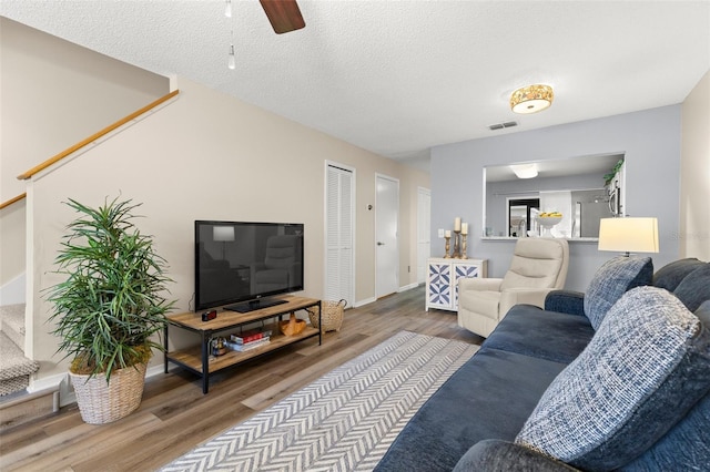 5100 Burchette Rd Unit 2702, Tampa, FL 33647 - living room with wood finished floors, ceiling fan, stairway, baseboards, and a textured ceiling