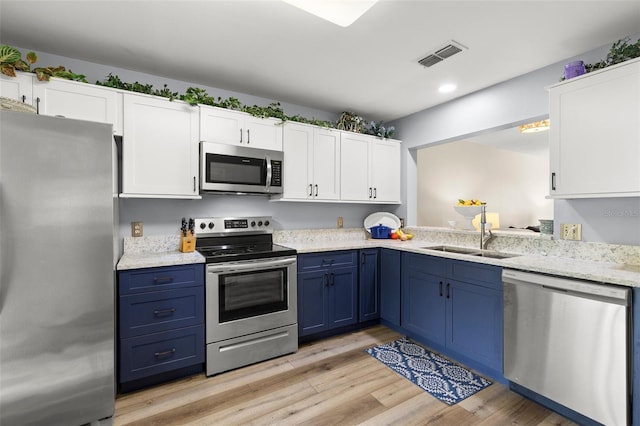 5100 Burchette Rd Unit 2702, Tampa, FL 33647 - kitchen featuring appliances with stainless steel finishes, blue cabinets, a sink, white cabinetry, and recessed lighting