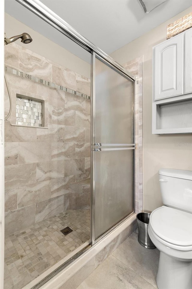 5100 Burchette Rd Unit 2702, Tampa, FL 33647 - bathroom featuring a stall shower, toilet, and tile patterned flooring