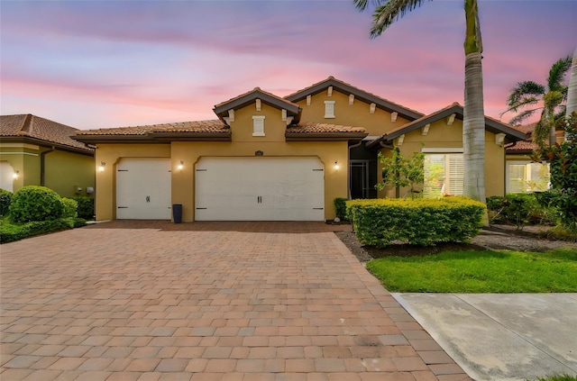 222 Toscavilla Blvd, Nokomis, FL 34275 - mediterranean / spanish house featuring stucco siding, decorative driveway, a garage, and a tile roof