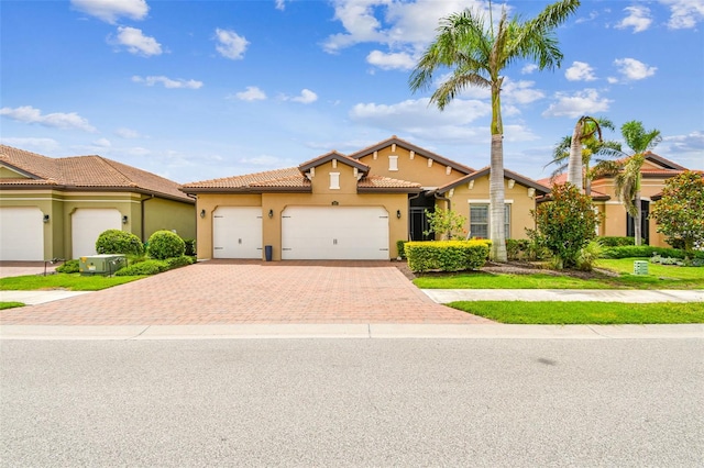 222 Toscavilla Blvd, Nokomis, FL 34275 - mediterranean / spanish-style home featuring stucco siding, decorative driveway, an attached garage, and a tiled roof