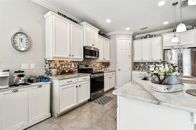 222 Toscavilla Blvd, Nokomis, FL 34275 - kitchen with appliances with stainless steel finishes, ornamental molding, a center island with sink, backsplash, and white cabinets