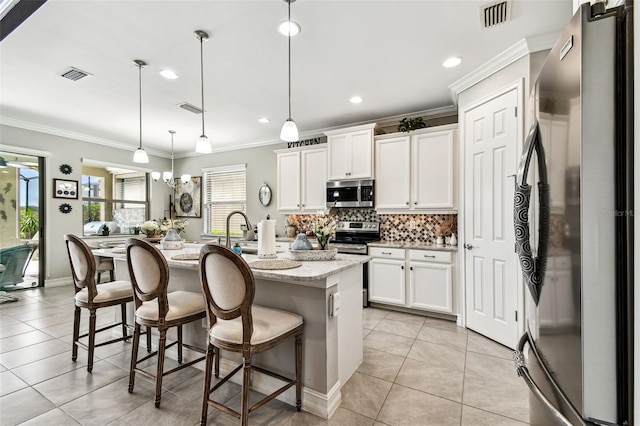 222 Toscavilla Blvd, Nokomis, FL 34275 - kitchen featuring stainless steel appliances, crown molding, backsplash, light tile patterned floors, and white cabinets