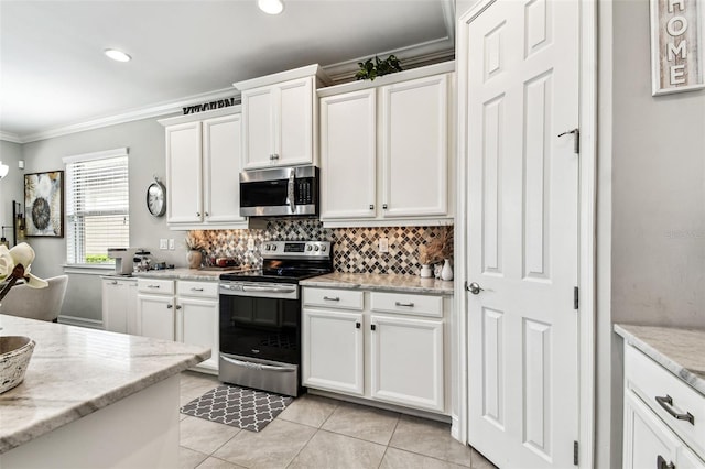222 Toscavilla Blvd, Nokomis, FL 34275 - kitchen with stainless steel appliances, crown molding, backsplash, white cabinetry, and light tile patterned flooring