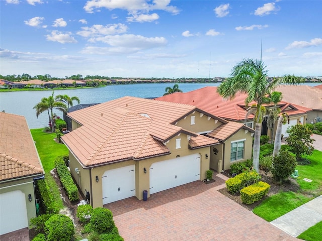 222 Toscavilla Blvd, Nokomis, FL 34275 - view of front of home with a garage, a tiled roof, decorative driveway, stucco siding, and a water view