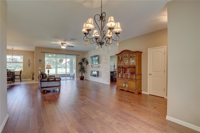 3813 Salida Delsol Dr, Sun City Center, FL 33573 - living room with a chandelier, wood finished floors, baseboards, and a fireplace