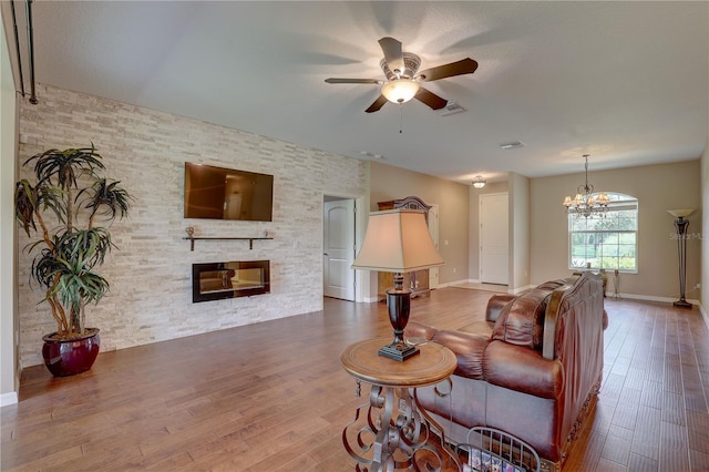 3813 Salida Delsol Dr, Sun City Center, FL 33573 - living room featuring a ceiling fan, wood finished floors, a fireplace, a chandelier, and baseboards