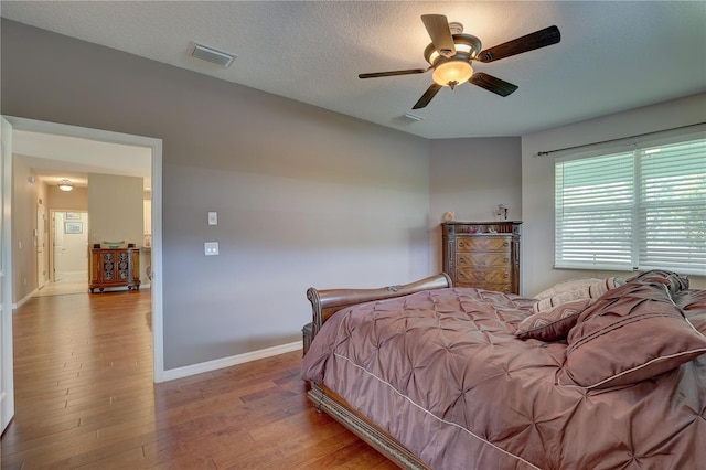 3813 Salida Delsol Dr, Sun City Center, FL 33573 - bedroom with wood finished floors, baseboards, a textured ceiling, and a ceiling fan