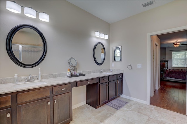 3813 Salida Delsol Dr, Sun City Center, FL 33573 - bathroom with double vanity, ensuite bathroom, baseboards, tile patterned floors, and ceiling fan
