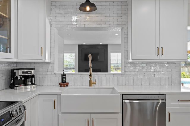 125 Live Oak Ln, Largo, FL 33770 - kitchen featuring appliances with stainless steel finishes, a sink, white cabinets, and tasteful backsplash