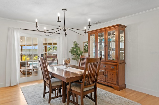 125 Live Oak Ln, Largo, FL 33770 - dining space with a chandelier, crown molding, light wood-type flooring, and baseboards