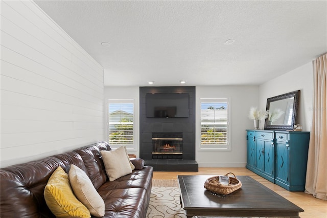 125 Live Oak Ln, Largo, FL 33770 - living room with plenty of natural light, light wood finished floors, a large fireplace, and a textured ceiling