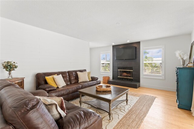 125 Live Oak Ln, Largo, FL 33770 - living room with light wood-style flooring, a tile fireplace, and baseboards