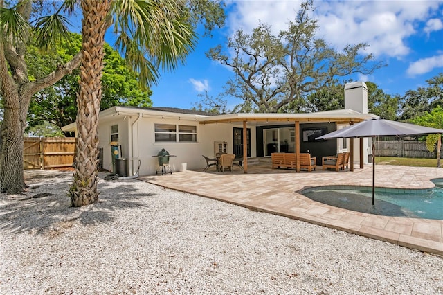 125 Live Oak Ln, Largo, FL 33770 - rear view of house with a chimney, stucco siding, a patio, and an outdoor hangout area