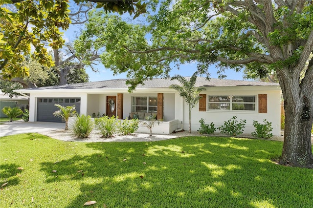 125 Live Oak Ln, Largo, FL 33770 - single story home with concrete driveway, a garage, a front lawn, and stucco siding