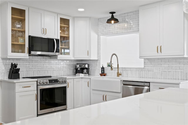 125 Live Oak Ln, Largo, FL 33770 - kitchen featuring appliances with stainless steel finishes, light countertops, tasteful backsplash, white cabinets, and recessed lighting