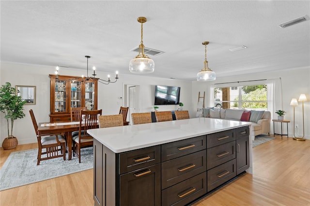 125 Live Oak Ln, Largo, FL 33770 - kitchen with open floor plan, light wood-type flooring, pendant lighting, a textured ceiling, and a chandelier