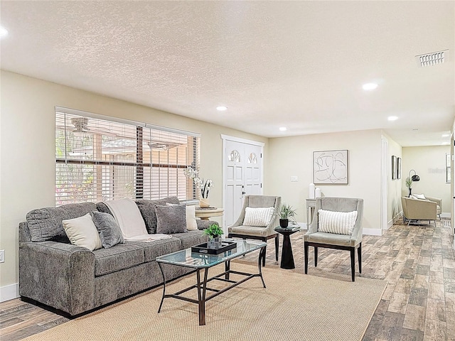 1025 Reading Rd, Lutz, FL 33558 - living room featuring light wood-type flooring, recessed lighting, baseboards, and a textured ceiling