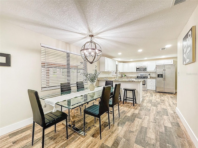 1025 Reading Rd, Lutz, FL 33558 - dining room featuring a chandelier, light wood-style flooring, baseboards, recessed lighting, and a textured ceiling