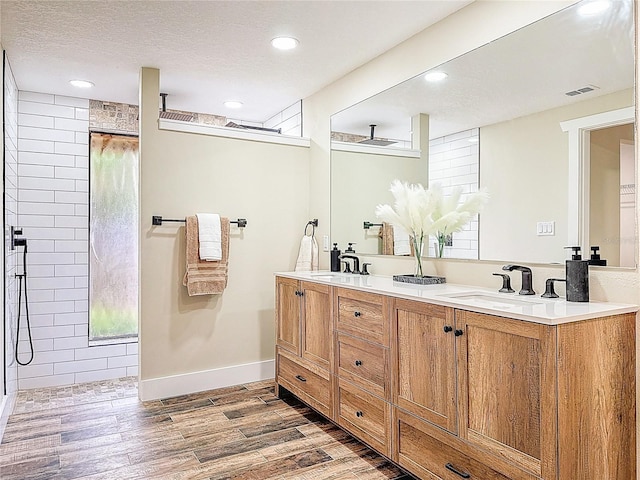 1025 Reading Rd, Lutz, FL 33558 - bathroom with wood finished floors, double vanity, recessed lighting, a tile shower, and baseboards