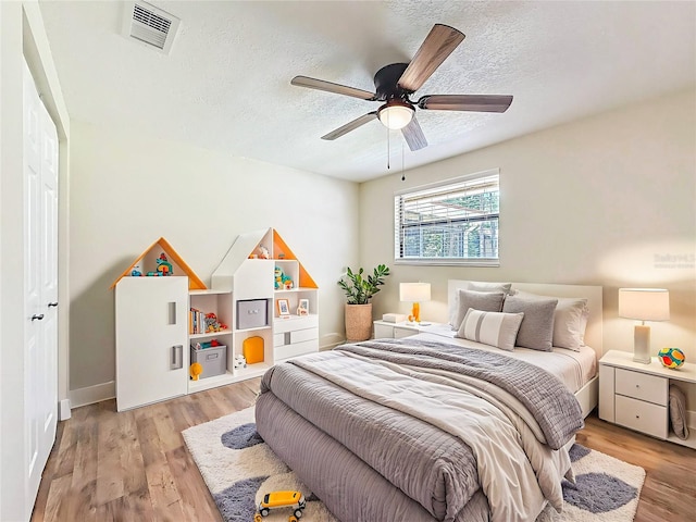 1025 Reading Rd, Lutz, FL 33558 - bedroom with light wood-style floors, a textured ceiling, ceiling fan, and baseboards
