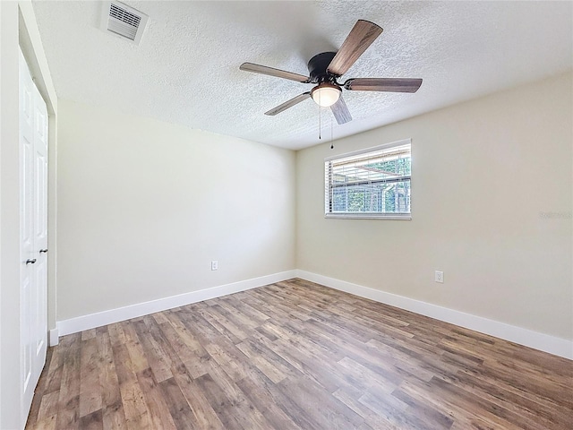 1025 Reading Rd, Lutz, FL 33558 - empty room with wood finished floors, a textured ceiling, a ceiling fan, and baseboards