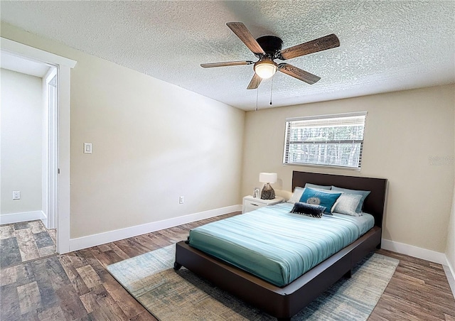 1025 Reading Rd, Lutz, FL 33558 - bedroom with wood finished floors, a textured ceiling, baseboards, and ceiling fan