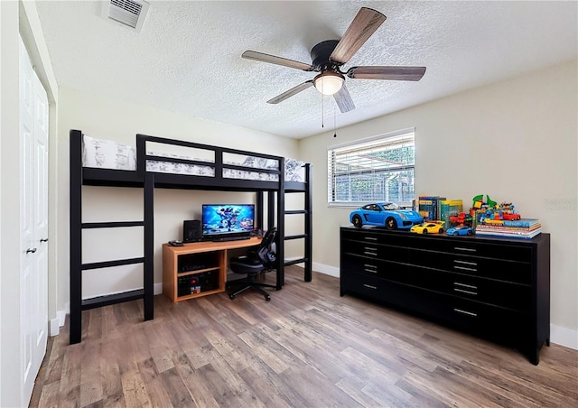 1025 Reading Rd, Lutz, FL 33558 - bedroom with wood finished floors, a textured ceiling, baseboards, and a ceiling fan