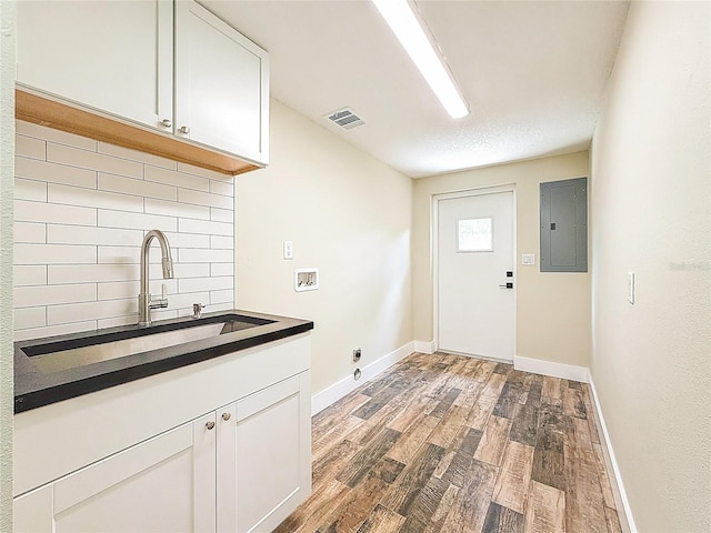 1025 Reading Rd, Lutz, FL 33558 - laundry area featuring cabinet space, electric panel, wood finished floors, washer hookup, and baseboards