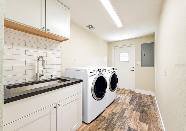1025 Reading Rd, Lutz, FL 33558 - laundry area featuring electric panel, cabinet space, light wood-style floors, washer and clothes dryer, and baseboards