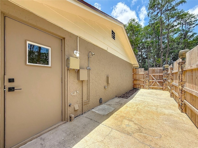 1025 Reading Rd, Lutz, FL 33558 - view of property exterior featuring stucco siding, a gate, and a patio area